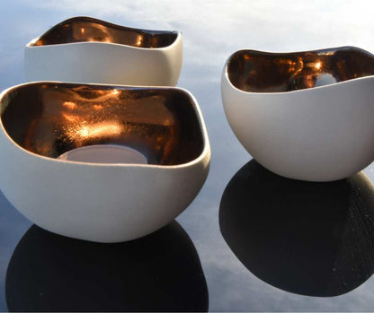 Nydelige håndlaget telysholdere i fargen krem og bronse. Skinner i solen og gir en lun følelse. Tenn lysene og gi rommet en avslappende atmosfære, sammen med hverdagen og gode minner. Disse telysholderene vil garantert gi mange gode stunder. 