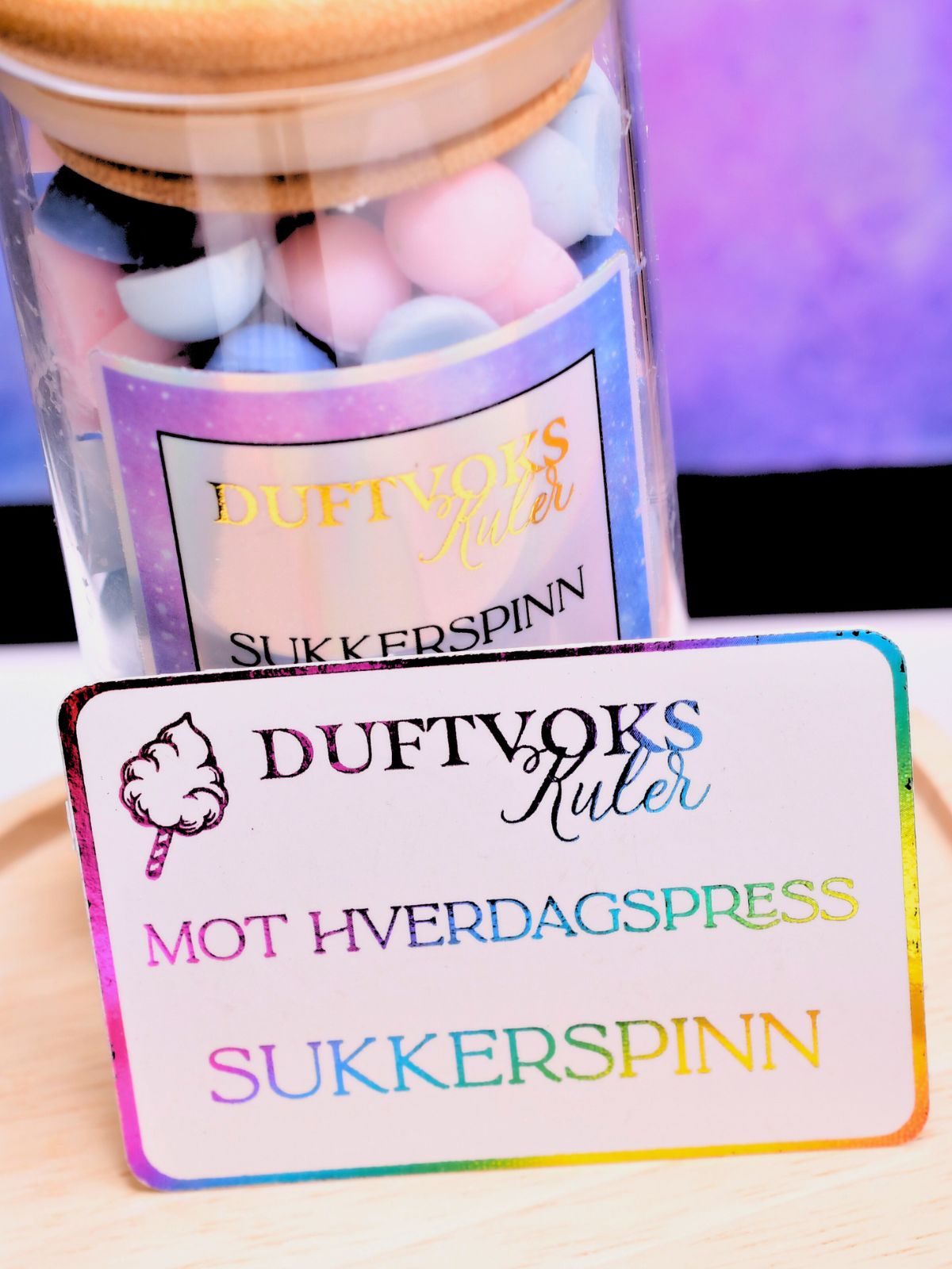 Kortet som følger med denne duftvoksen har reinbuens farger. På dette fine kortet står det at disse duftvokskulene er mot hverdagspress og lukter sukkerspinn. Et søtt kort som følger med glasset. 