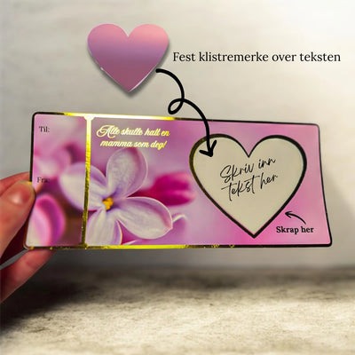 Informasjon om hvordan man gjør klart morsdagskortet. Først skriver man teksten man ønsker inni hjerte feltet på kortet. Etterpå festes skrapeklistremerke over teksten du har skrevet. Nå er det bare for  verdens beste mamma å skrape bort hjertet for å finne ut hva du har skrevet til henne. Kortet er lilla med blomster på, og har nydelige gullfolierte detaljer som skinner i lyset. Luksuriøst kort som garantert varmer et mammahjerte. 