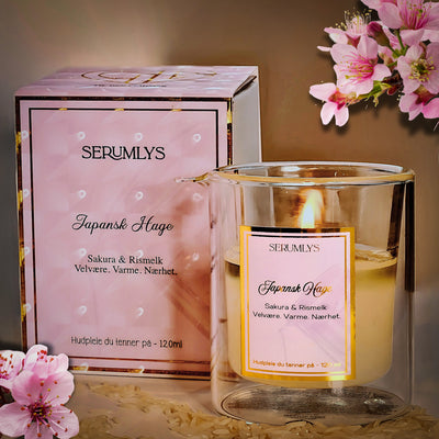Serumlys tent og man kan se oljene som har smeltet, klar til å helles på kroppen og gi både kropp og sjel en uforglemmelig opplevelse. I bakgrunnen kan man se esken den kommer i. Rosa og gull deltaljer. Eksklusivitet og luksus i hverdagen, og opplevelser som gir så mye mer. 