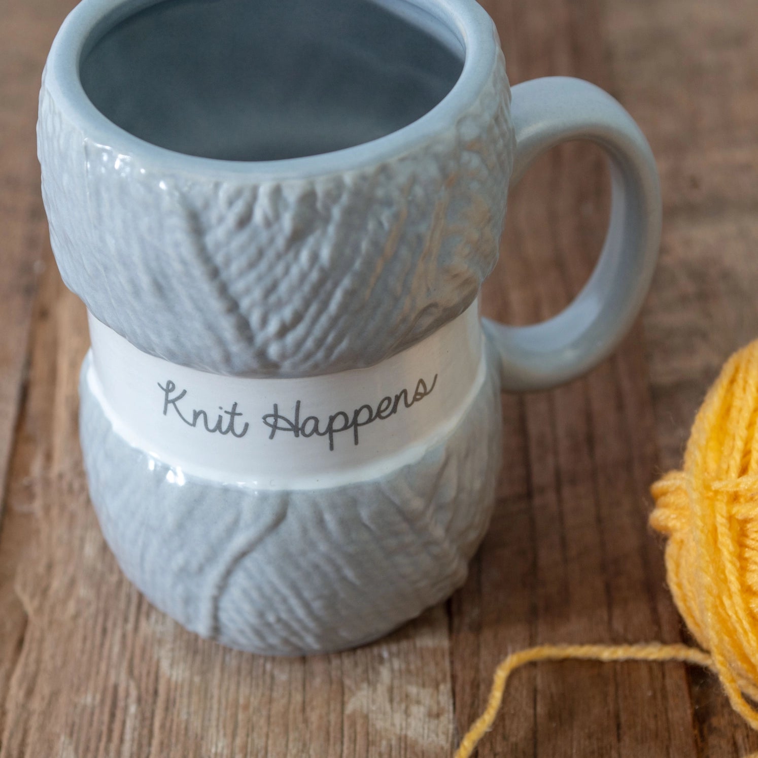 Garn-nøste kaffekopp med morsom tekst "knit happens"