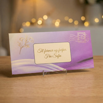 Konvolutt i tykk kartong. Håndlaget til konfirmasjonsinvitasjonene. Felt til å skrive hvem kortet er til på. Gull stemplet detaljer på konvolutten. 