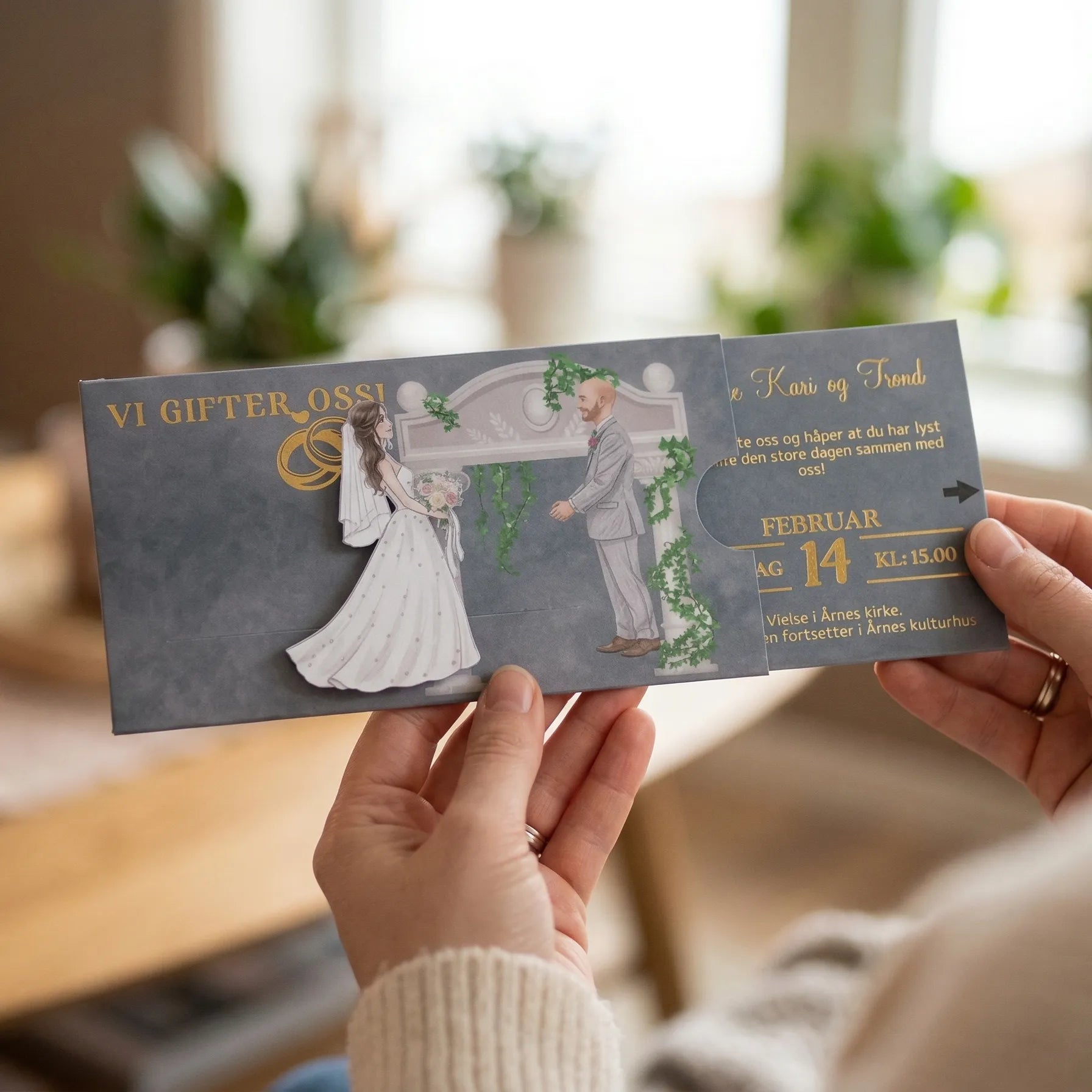 Invitasjon til bryllup. Bryden går mot brudgommen når man drar ut informasjonsdelen på kortet. Vi gifter oss og to gullringer er gullfoliert på kortet. Detaljene med tid, dato, sted og annen informasjon kommer også i gullfoliering, og kan tilpasses med gjestens navn og med sin egen tekst. Kortet kan også lamineres i matt eller glossy type. En interaktiv og eksklusiv invitasjon som gir wow faktor.