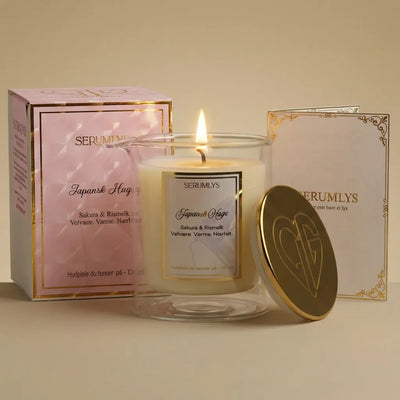 Et tent serumlys med lokket som står inntil glasset. På sidene står emballasjen og brosjyren som følger med produktet. Et hudpleieprodukt som gir ro og velvære. En spabehandling hjemme på ditt eget bad. Laget med naturlige planteoljer som smelter til et varmt og pleiende body serum som kan brukes på hele kroppen etter en dusj eller et bad. Lag deg selv ditt eget lille rituale der du setter deg selv før alt annet.