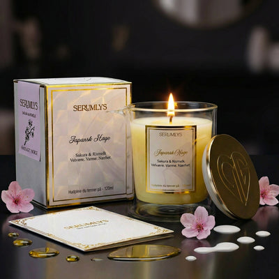 Et tent serumlys med lokket som står inntil glasset. På sidene står emballasjen og brosjyren som følger med produktet. Et hudpleieprodukt som gir ro og velvære. En spabehandling hjemme på ditt eget bad. Laget med naturlige planteoljer som smelter til et varmt og pleiende body serum som kan brukes på hele kroppen etter en dusj eller et bad. Lag deg selv ditt eget lille rituale der du setter deg selv før alt annet.