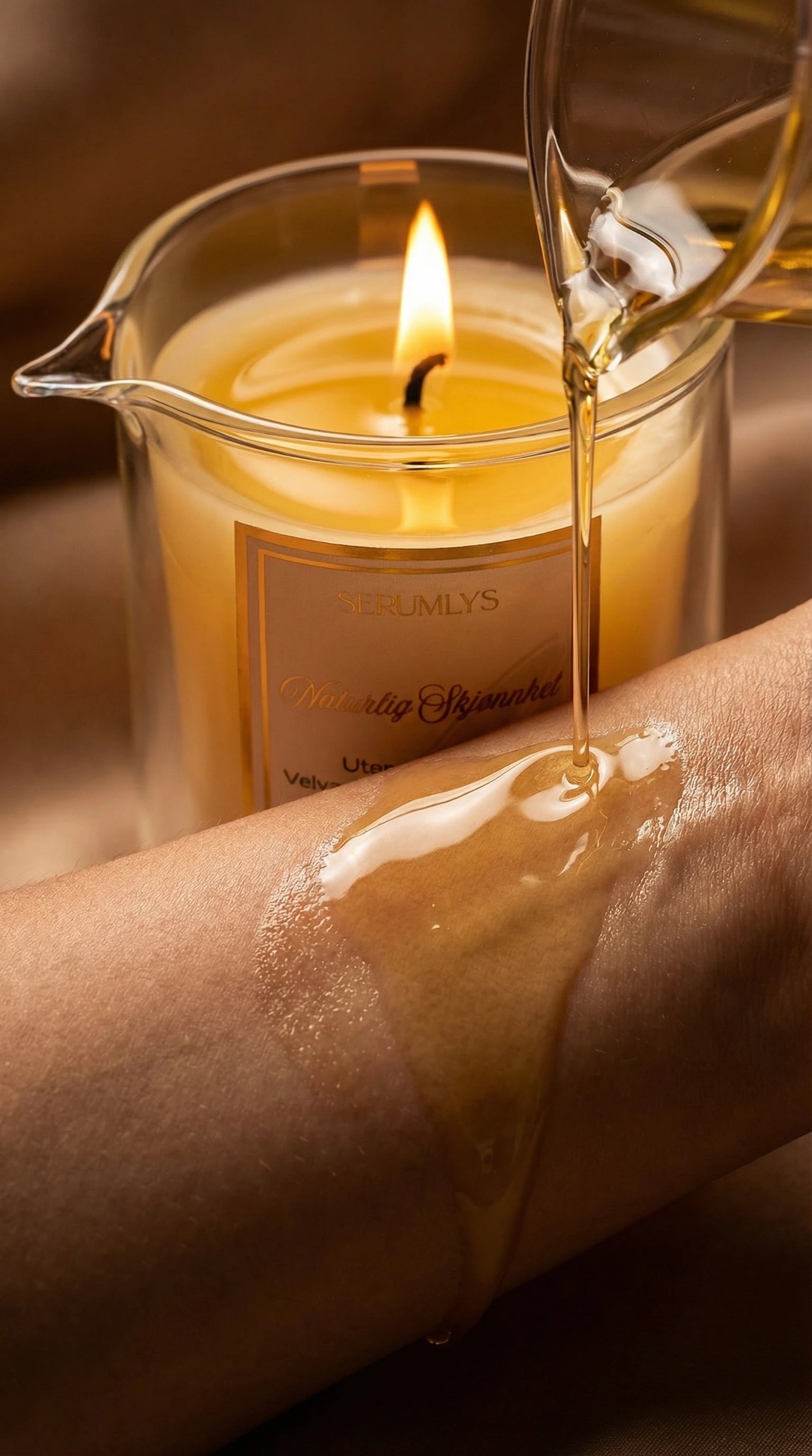 Et serumlys i glass med helletut med naturlige planteoljer som står tent, der litt av bivoksen har smeltet. Et annet glass viser at oljen helles på armen. En varm og luksuriøs følelse med høyt fokus på velvære og egenomsorg. Gode lette oljer som kan brukes på hele kroppen.