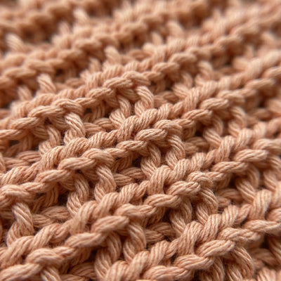 Strikket vaskekluter av 100% bomull. Her ser man detaljene og nærbilde av maskene og mønstret. Denne kluten er i fargen fersken som gir badet ditt en frisk detalj med sin nydelige farge. 