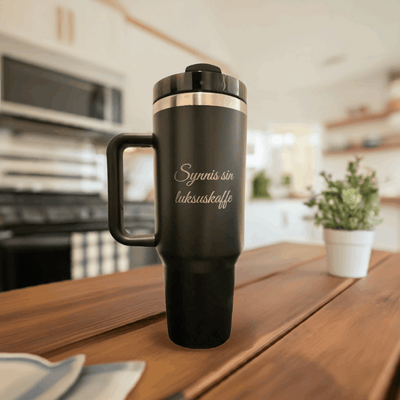 Svart lasergravert termokopp på kjøkkenbenken. Synnis sin luksuskaffe