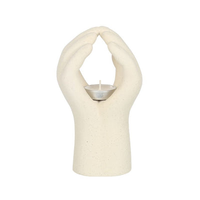 Hender som holder telys. Telysholder i keramikk i fargen beige. Man putter telyset i midten av hendene og dette gir en indre ro. Unikt design til et hvert hjem. 