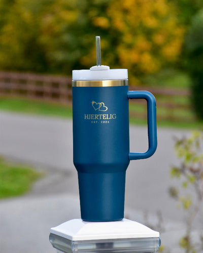 Tumbler med sugerør og håndtak i blå farge med gullkant og logo