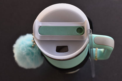 En termokopp med sugerør og håndtak som viser at man kan vri lokket for å drikke uten sugerør