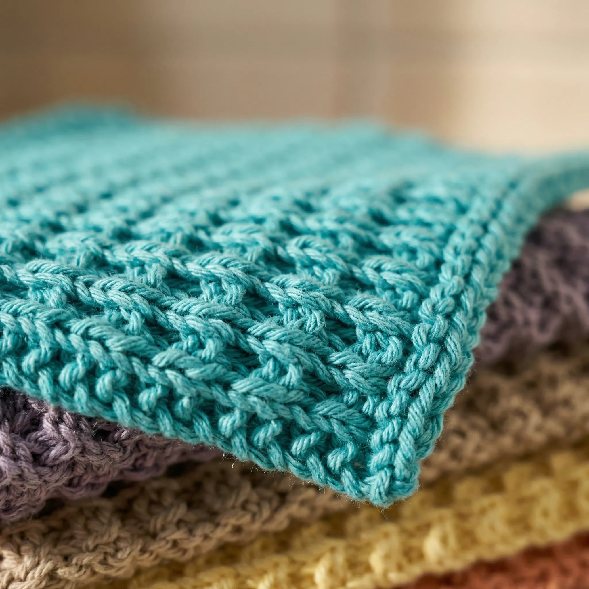 Turkis vaskeklut av hundre prosent bomull. Her er et nærbilde av mønsteret og detaljene i kluten. 