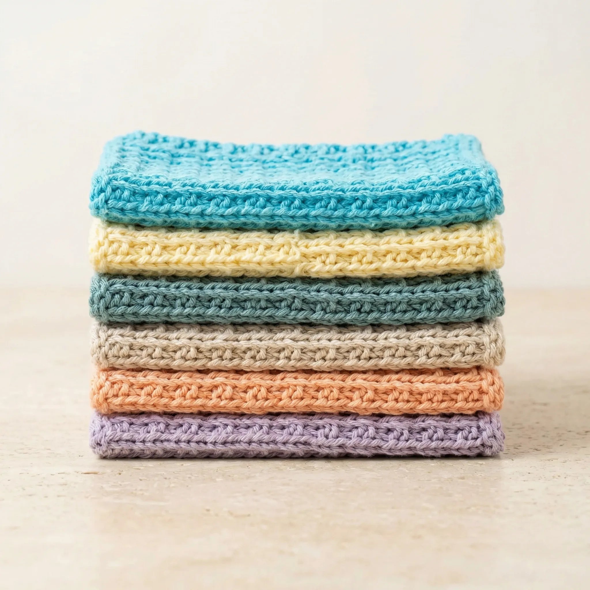 Vaske kluter man kan bruke enten på kjøkkenet eller badet. Disse klutene er håndstrikket i 6 forskjellige farger i 100% bomull. Her kan man se fargene vi har. Klutene er brettet og ligger oppå hverandre. 