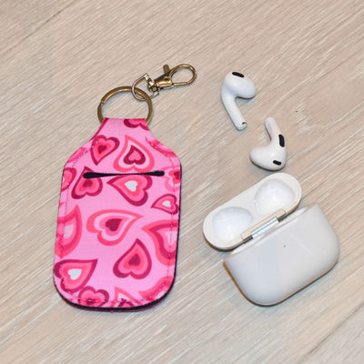 Veske til airpodsene dine med rosa hjertemotiv. 