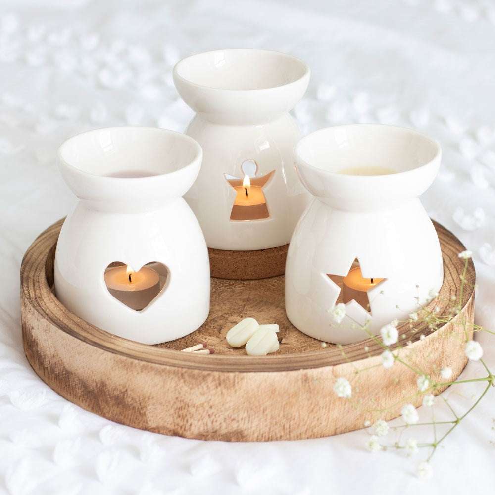 Voks og oljebrenner i forskjellige design. Her ser du de i bruk på et bord. Tenn et telys og putt det inn i brenneren. Putt noen voksbiter på toppen og la de smelte. Fyll hjemme med valgfrie lukter til rommet. 