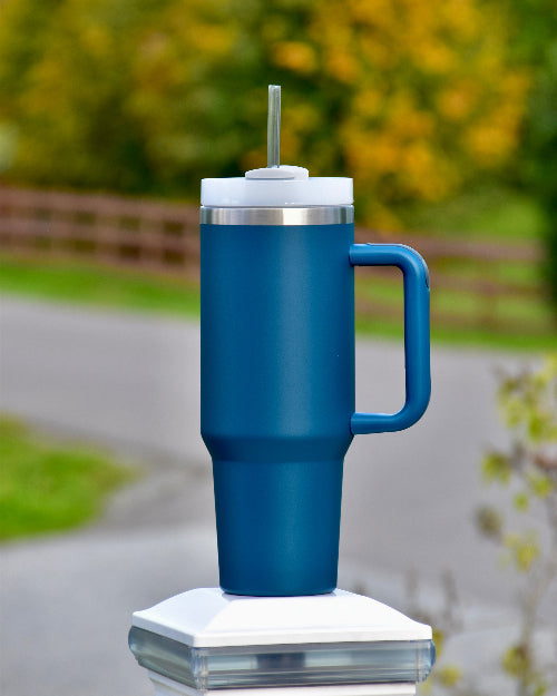 Stor blå tumbler med sugerør og håndtak. God kvalitet termokopp som holder drikken kald eller varm i mange timer. Passer perfekt i koppholderen i bilen, og du vil ha 1,2 liter med drikke gjennom dagen. Personlig gave med valgfri tekst