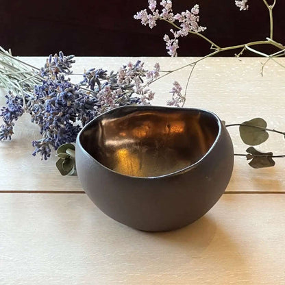 Brun håndlaget telysholder fra Frankrike, som står ved siden av blomster på et bord