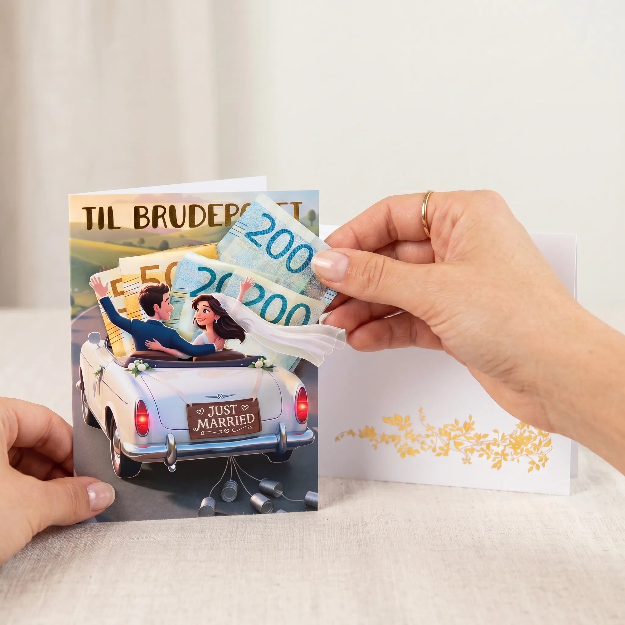 Hånd som trekker pengesedler ut av den skjulte pengelommen i et håndlaget bryllupskort med Just Married-illustrasjon