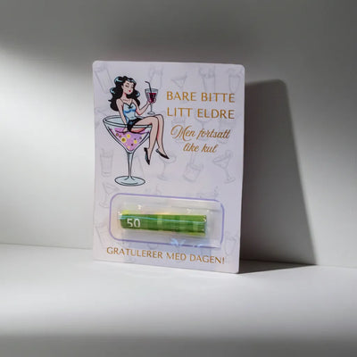 Bursdags kort med egen lomme til å putte penge gaven i. Det er en plastlomme, man enkelt kan legge ønsket sum med penger inni, så er det bare å rive av den dobelsidige tapen og kortet med pengegaven er klar til å gi til den som har bursdag. På kortet står teksten "bare bitte litt eldre, men fortsatt like kul". Gratulerer med dagen! En fin og gøyere måte å gi bort penger i gave på. 