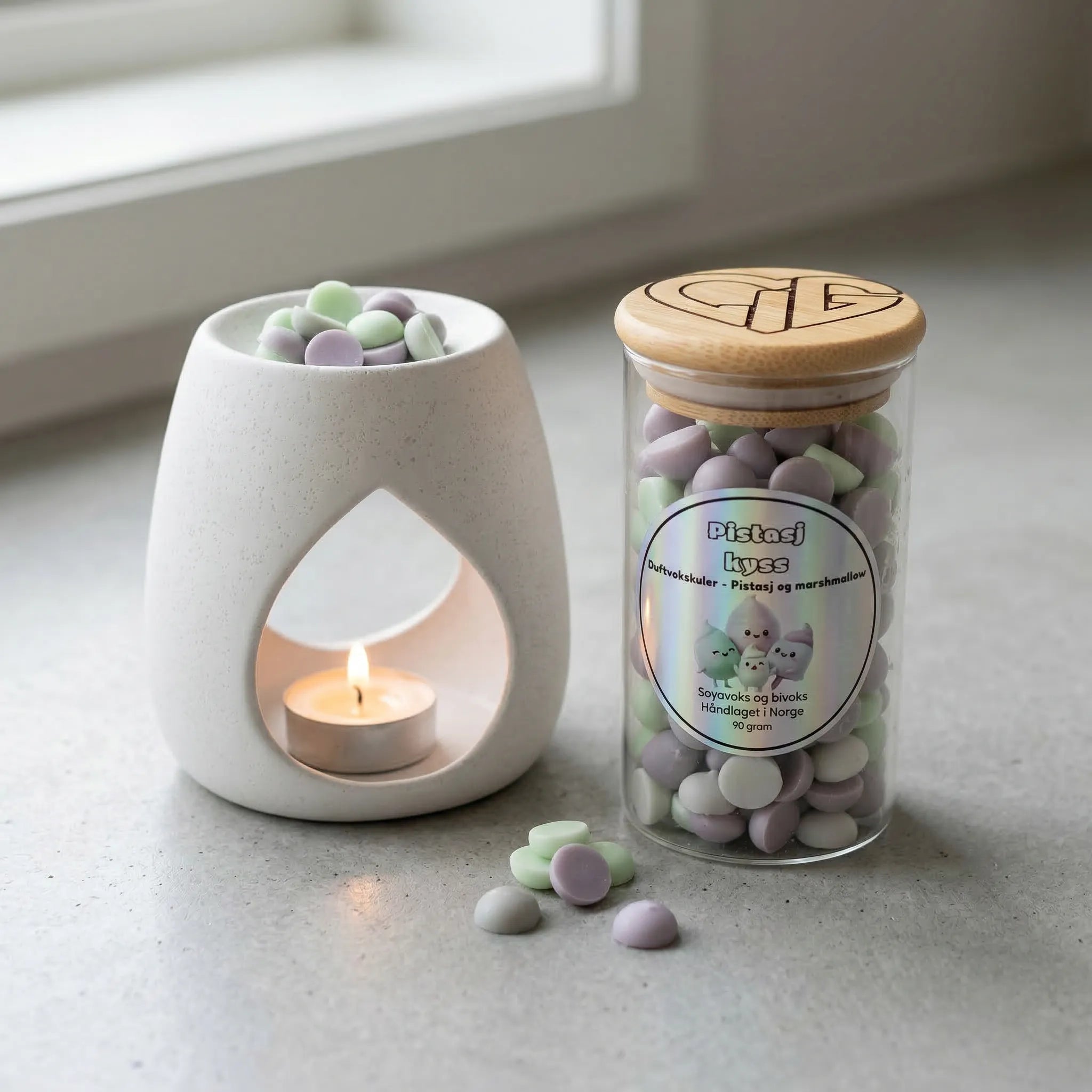 Duftvoks i glass med duft av pistasj og marchmallows. Glasset inneholder 90g voks. En voksbrenner med telys smelter noen vokskuler for å spre god duft ut i rommet. Håndlaget i Norge med bivoks og soyavoks.