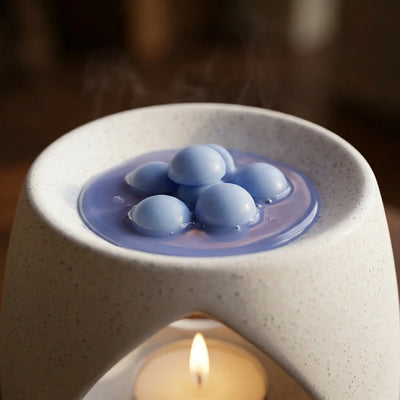 Duftvoks i blå farge som smelter i en duftbrenner med telys. Duften heter Tung himmel og er en lett og frisk duft av regn, havbris og mose. Som duften man kjenner etter et kraftig regnskyll. Håndlaget i norge med bivoks og soyavoks.