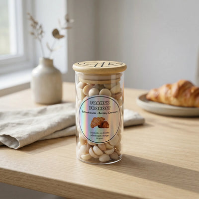 Små brune og beige duftvokskuler i et glass med trelokk. Fransk frokost har duft av nystekt croissant. Til bruk sammen med en duftbrenner for å spre herlig duft i hjemmet.