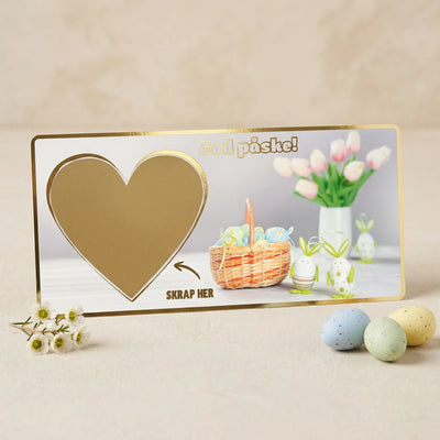 Et gavekort med skrapefelt. Gaven skrives ned på kortet, og klistremerke hjerte festes over teksten. Mottaker må skrape frem gaven sin. Håndlaget i Norge. Gullfolierte detaljer.