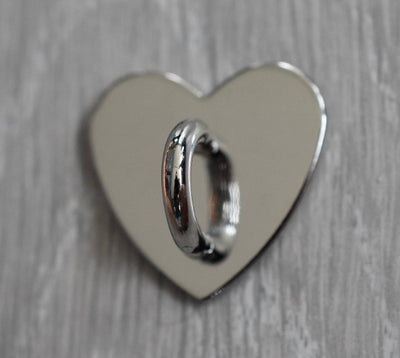 En sølvkrok med hank til å feste småsaker på.