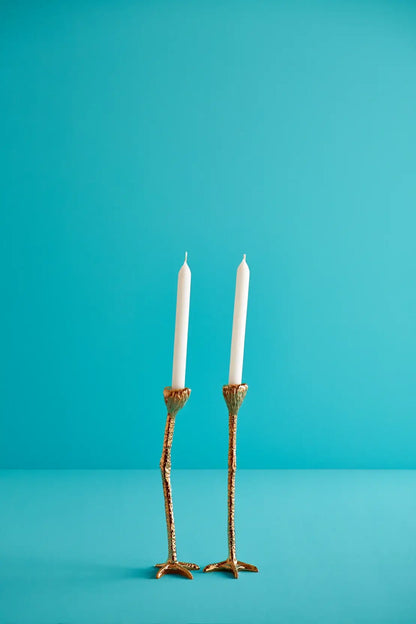 to lysestaker med strutseben i gull med to hvite stearinlys. Blå bakgrunn. Tenn lysene og hjemmet ditt vil føles både morsomt, lukseriøst og skille seg ut . Detaljene på beina gjør at de ser veldig ekte ut. 