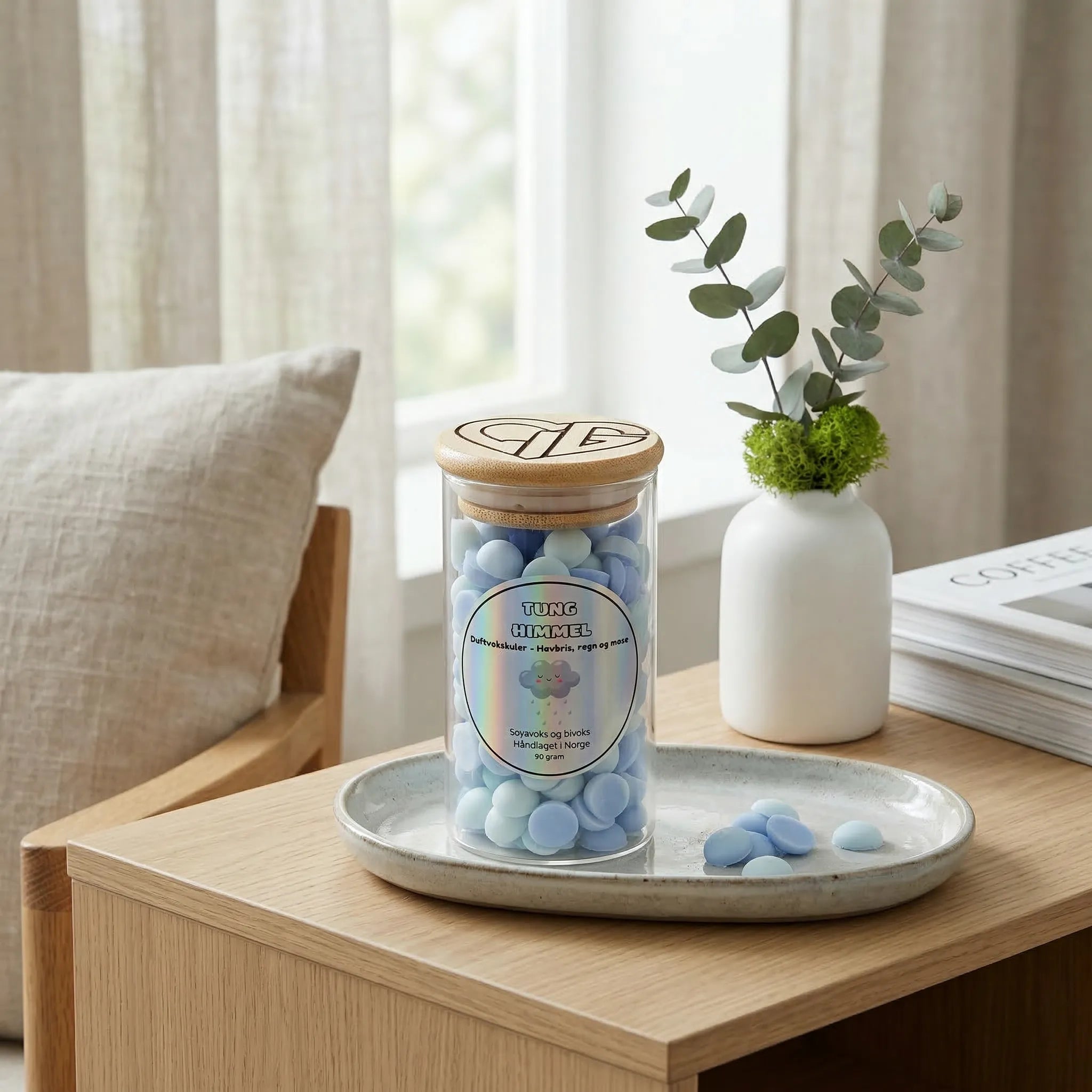 Duftvokskuler med duft av regn, havbris og mose. Håndlaget i norge med soyavoks og bivoks. Noen kuler er tatt ut av glasset og lagt ved siden av glasset. Glasset inneholder 90g voks. Kulene er lys blå og lys grønn.
