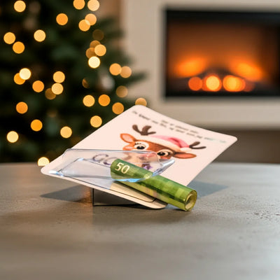 Julekort med pengelomme. Her ser man hvordan den brukes. Putt ønsket pengesum i pengesedler inni plastlommen på kortet og lim den igjen med den dobbelsidige tapen på kortet. Her har du en fantastisk måte å gi bort penger på til jul. Dette kortet er en morsom og unik måte å gi bort pengegaver som ellers kan være litt kjedelig på! Årets julegavetips!