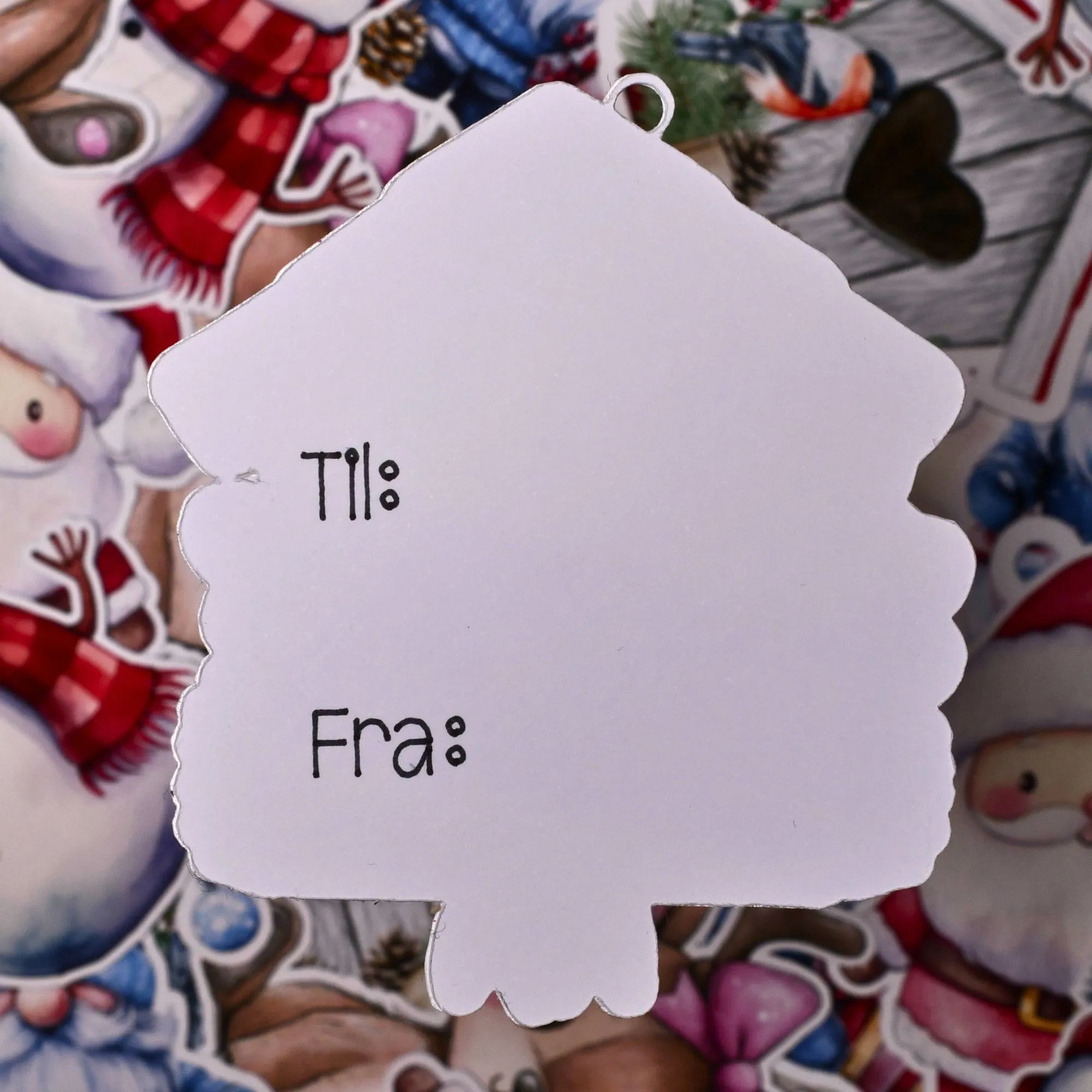 Baksiden av til og fra lappen som er formet som en fuglekasse. Til og Fra er allerede skrevet på alle lappene. Håndlaget i Norge. Lappene festes enkelt på en gave ved å bruke det utskjærte hullet med julegavebåndet