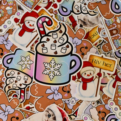 En til-fra lapp der man ikke vet hvem som har gitt gave, eller hvem gaven er til. For å finne ut av det, må riveflappen rives av på fremsiden. Et søtt design av en kopp med kakao og krem med sjokoladebiter, marshmallows og en candy cane. Håndlagde lapper fra Norge.