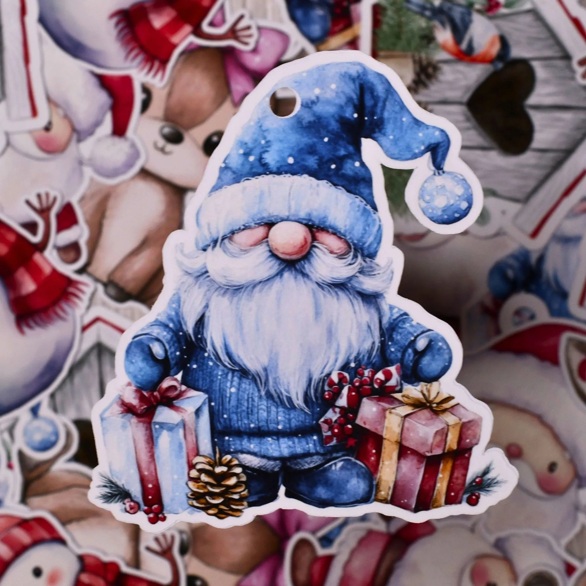 En til og fra lapp som er håndlaget. Designet som en fin nisse med blåe klær som står ved siden av to gaver. Hullet ut slik at man enkelt fester lappen til gavebåndet. På baksiden står Til og Fra skrevet på, så alt som trengs er å skrive på navnene til de som gir gaven og de som skal motta.