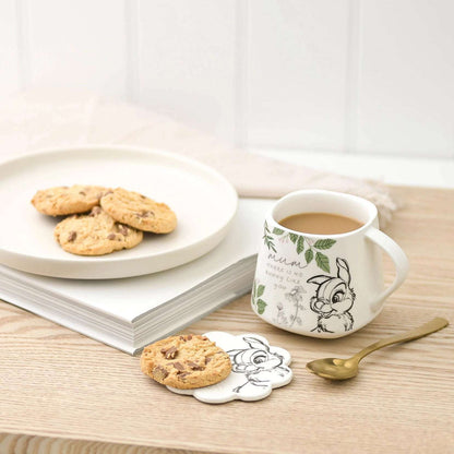 Trampe kaffekopp med brikke som står på et bord.